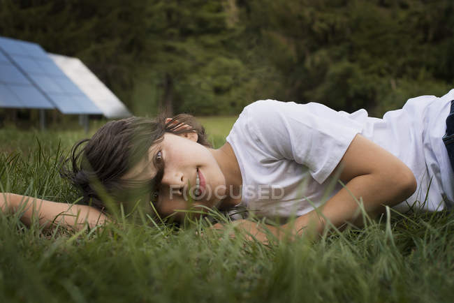 Мальчик, лежащий в траве — стоковое фото