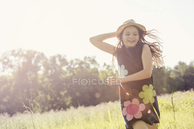 Дівчина в солом'яному капелюсі на лузі — стокове фото