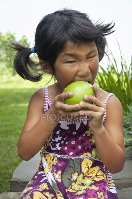 Niño masticando una manzana grande - foto de stock