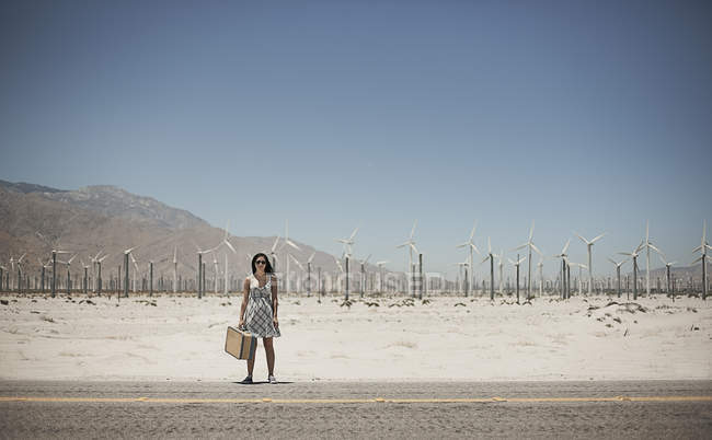 Женщина с чемоданом на краю шоссе . — стоковое фото