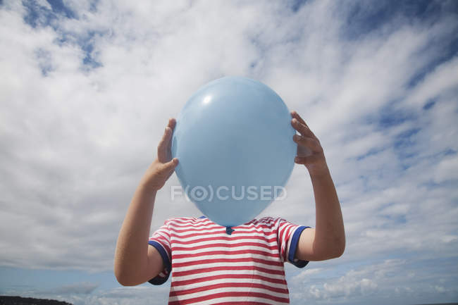 Junge steht mit Luftballon — Stockfoto