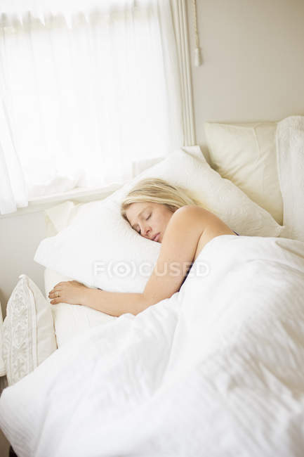Женщина спит в кровати — стоковое фото