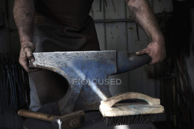 Blacksmith standing at an anvil — Stock Photo