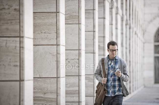 Мужчина держит в руках смартфон — стоковое фото