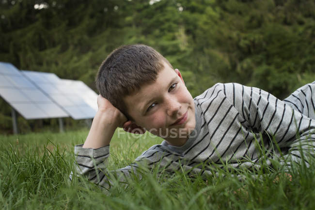 Мальчик, лежащий в траве — стоковое фото