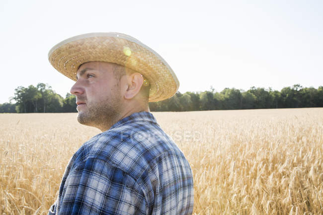 Фермер стоїть на пшеничному полі — стокове фото