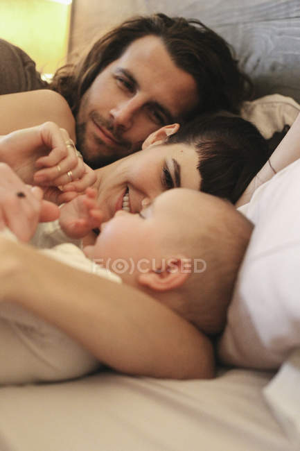 Madre, padre e bambino a letto — Foto stock