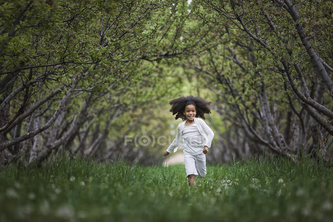 Criança correndo ao longo árvore ramos arco — Fotografia de Stock