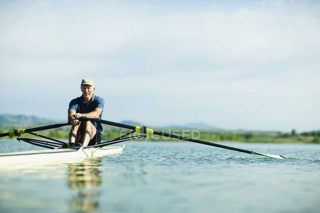 Man rowing a single scull boat — Stock Photo