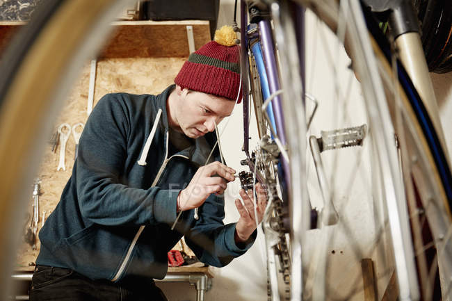 Jeune homme réparer un vélo . — Photo de stock
