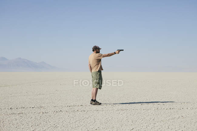 Homem apontando arma de mão — Fotografia de Stock