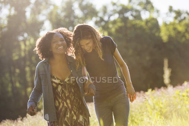 Две женщины, идущие через поле — стоковое фото