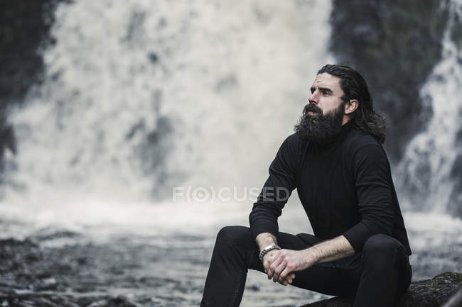 Homem sentado no riacho da montanha . — Fotografia de Stock