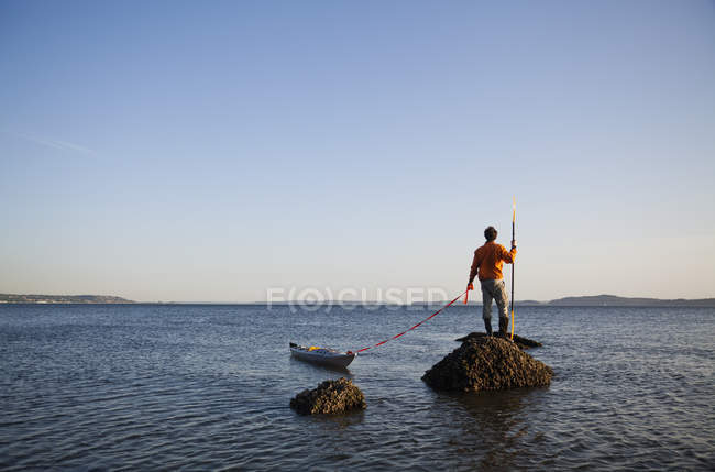 Морской каякер на скале — стоковое фото