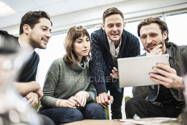 Cuatro personas, colegas en una reunión - foto de stock