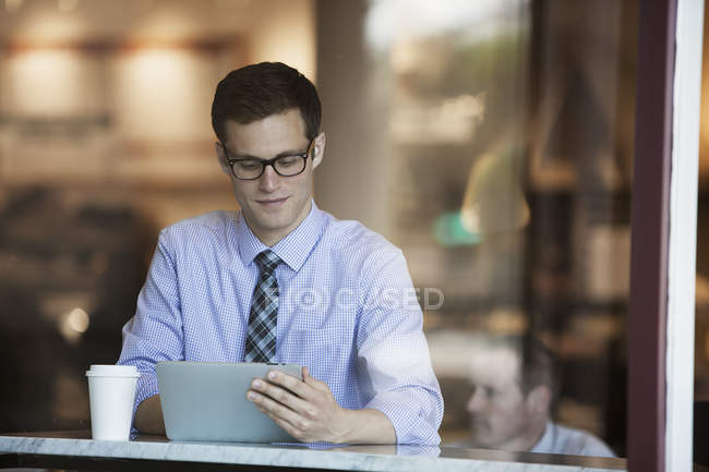 Homme d'affaires utilisant une tablette numérique dans un café . — Photo de stock