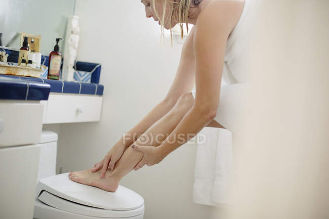 Mulher em toalha branca em um banheiro — Fotografia de Stock