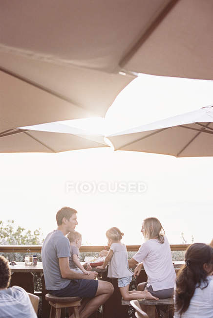 Casal sentado sob um guarda-sol em um restaurante — Fotografia de Stock