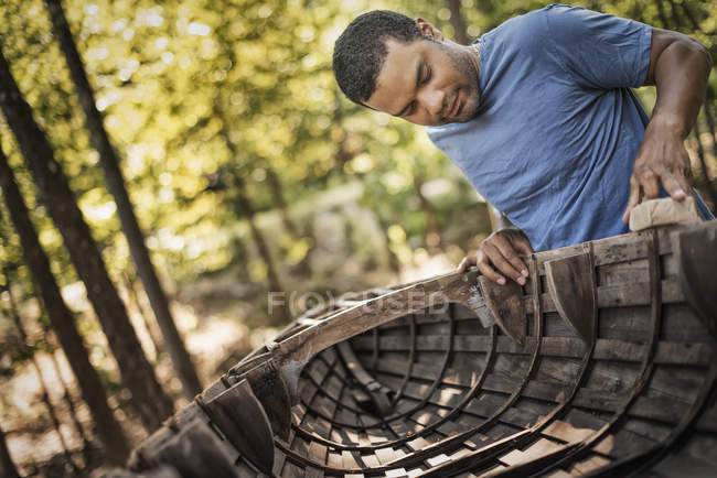 Чоловік ремонтує традиційний дерев'яний човен . — стокове фото