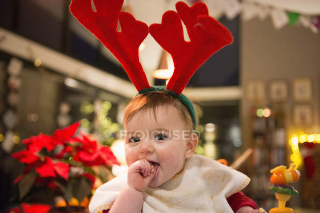 Baby girl wearing felt antlers — Stock Photo
