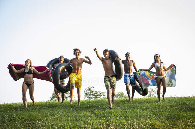 Teenagers running across the grass — Stock Photo
