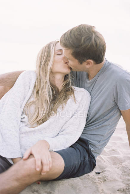 Pareja besándose en una playa - foto de stock