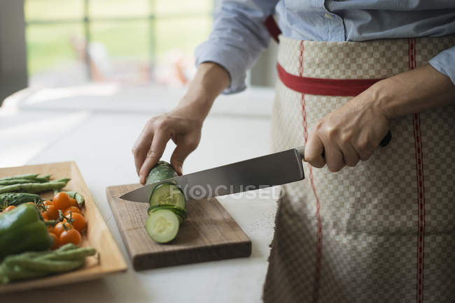 Mujer rebanando verduras orgánicas - foto de stock