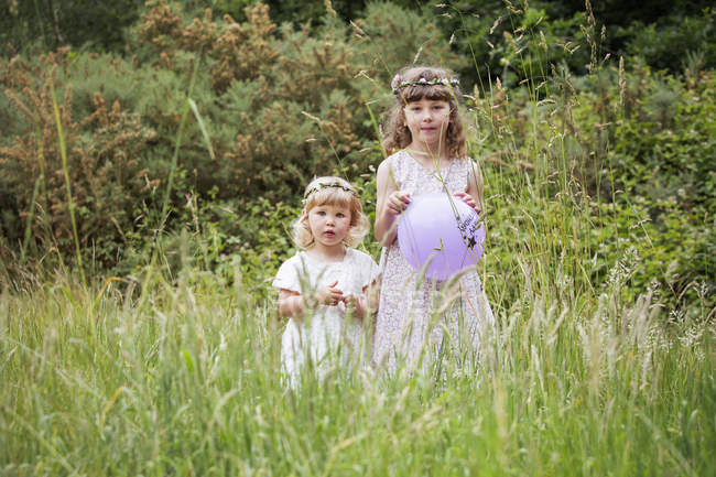 Meninas de pé em um prado . — Fotografia de Stock
