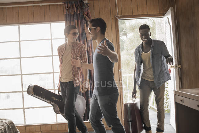Trois jeunes hommes dans une chambre de motel — Photo de stock