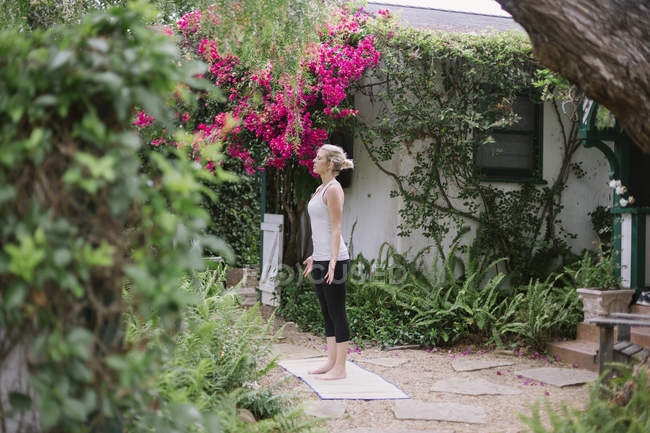 Mujer haciendo yoga en un jardín
. - foto de stock