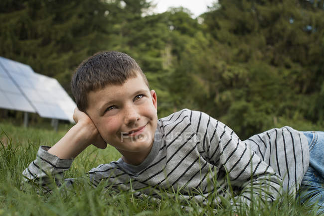 Junge liegt im Gras — Stockfoto