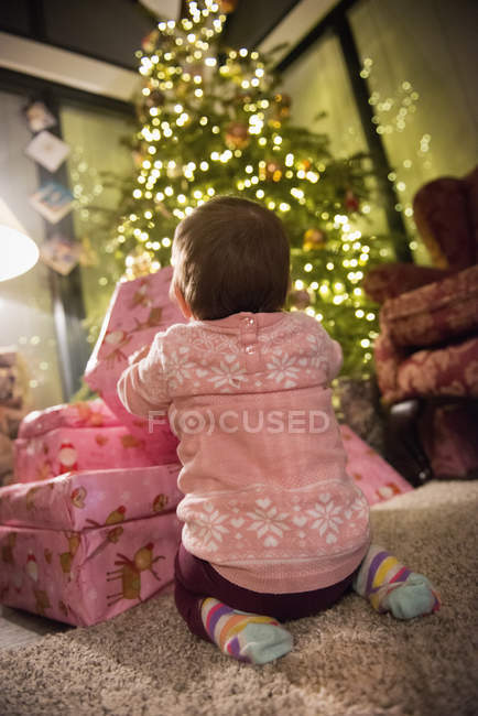 Niño al lado de un montón de regalos - foto de stock