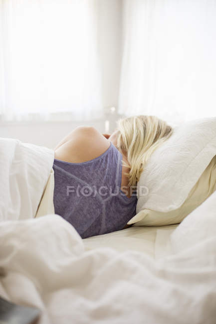 Mulher dormindo numa cama — Fotografia de Stock