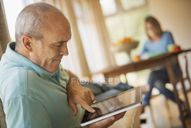Man sitting in a traditional farmhouse kitchen — Stock Photo