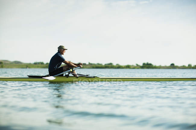 Hombre en un bote de remos en el agua
. - foto de stock