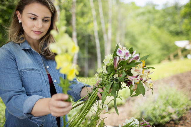 Frau mit Sommerblumen im Garten. — Stockfoto
