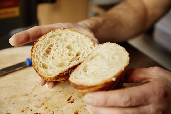 Uomo con in mano un croissant — Foto stock