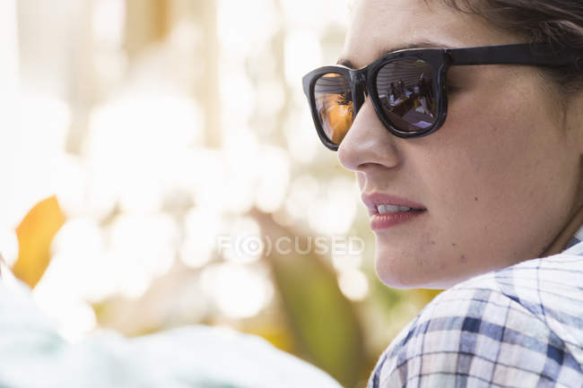Femme portant des lunettes de soleil tournant — Photo de stock