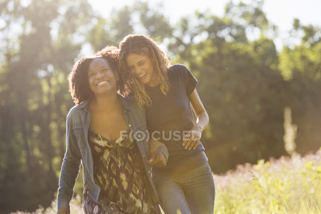 Dos mujeres caminando por un campo - foto de stock