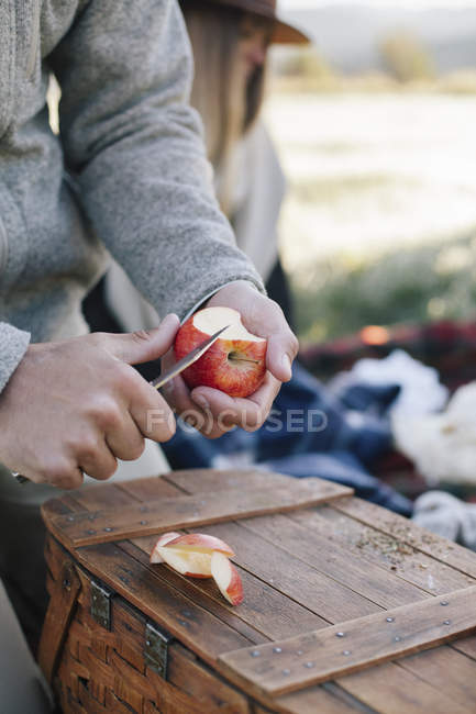 Hombre cortando una manzana - foto de stock