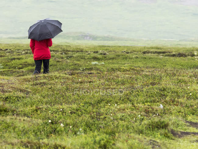 Femme marchant sous la pluie — Photo de stock