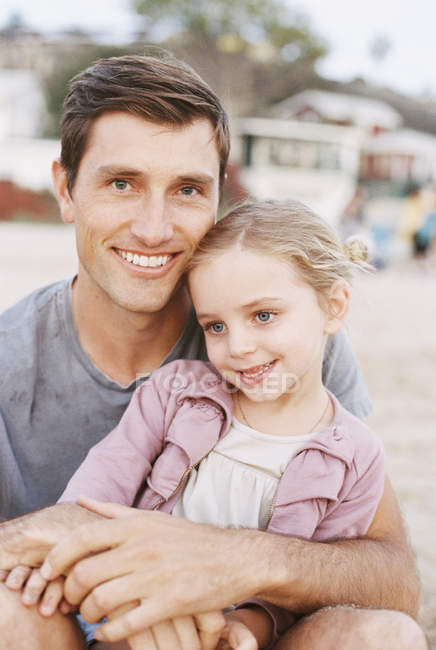 Young girl sitting on her father's lap — Stock Photo