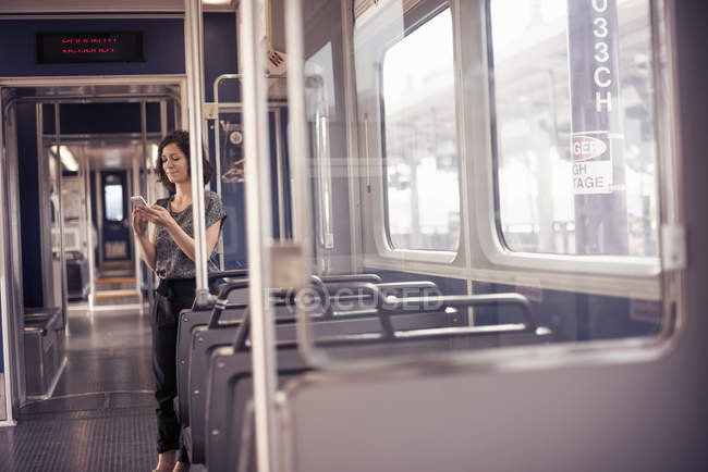 Mujer en un autobús comprobando el teléfono celular - foto de stock