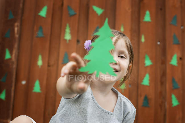 Enfant jouant avec un arbre vert — Photo de stock