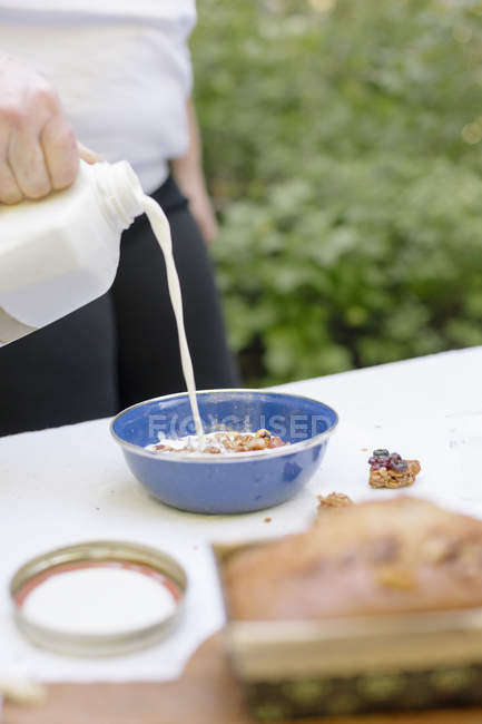 Donna versando latte fresco — Foto stock