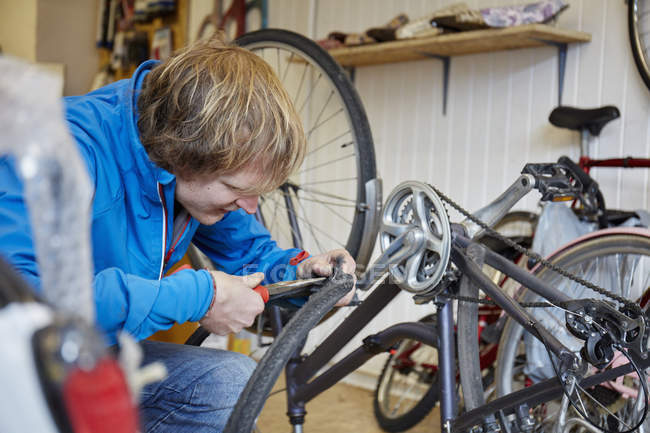 Giovane che ripara una bicicletta . — Foto stock