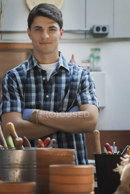 Man in a potting shed by work bench. — Stock Photo