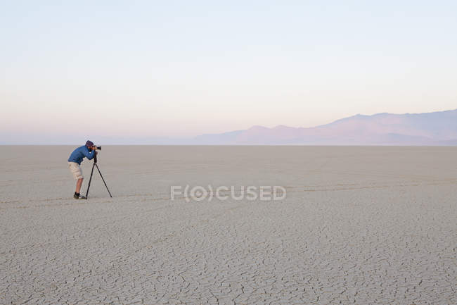Homem com câmera e tripé — Fotografia de Stock