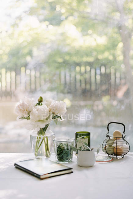 Flores de peonía, cuaderno y frascos — Stock Photo