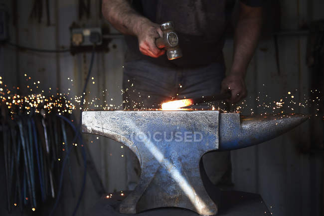 Ferreiro moldar um pedaço quente de ferro — Fotografia de Stock